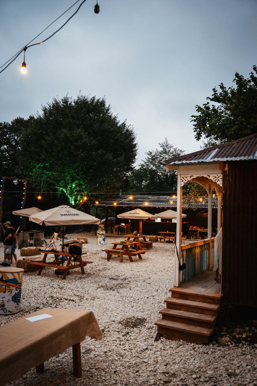 Gulsunda courtyard at dusk with string lights, picnic tables and Oda pavilion